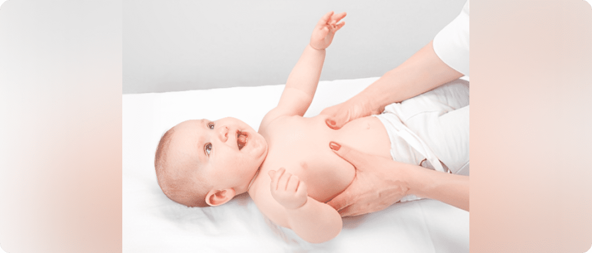 A baby lying down while being gently massaged.