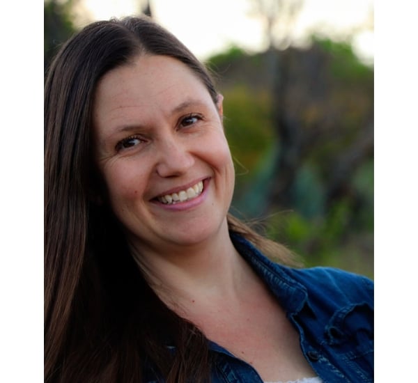 Smiling woman outdoors with natural background.