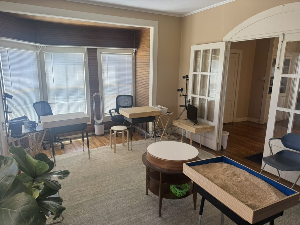 A cozy living room with a shuffleboard table and a small round table.