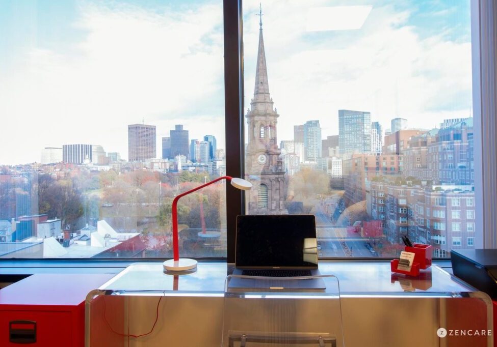 A modern desk setup with city skyline and church steeple view.